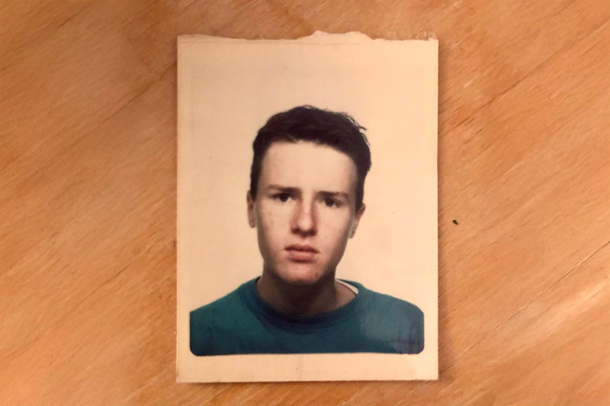 An old passport photograph of me age 17, laid on a wooden floor