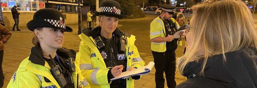 Two officers talking to a member of the public