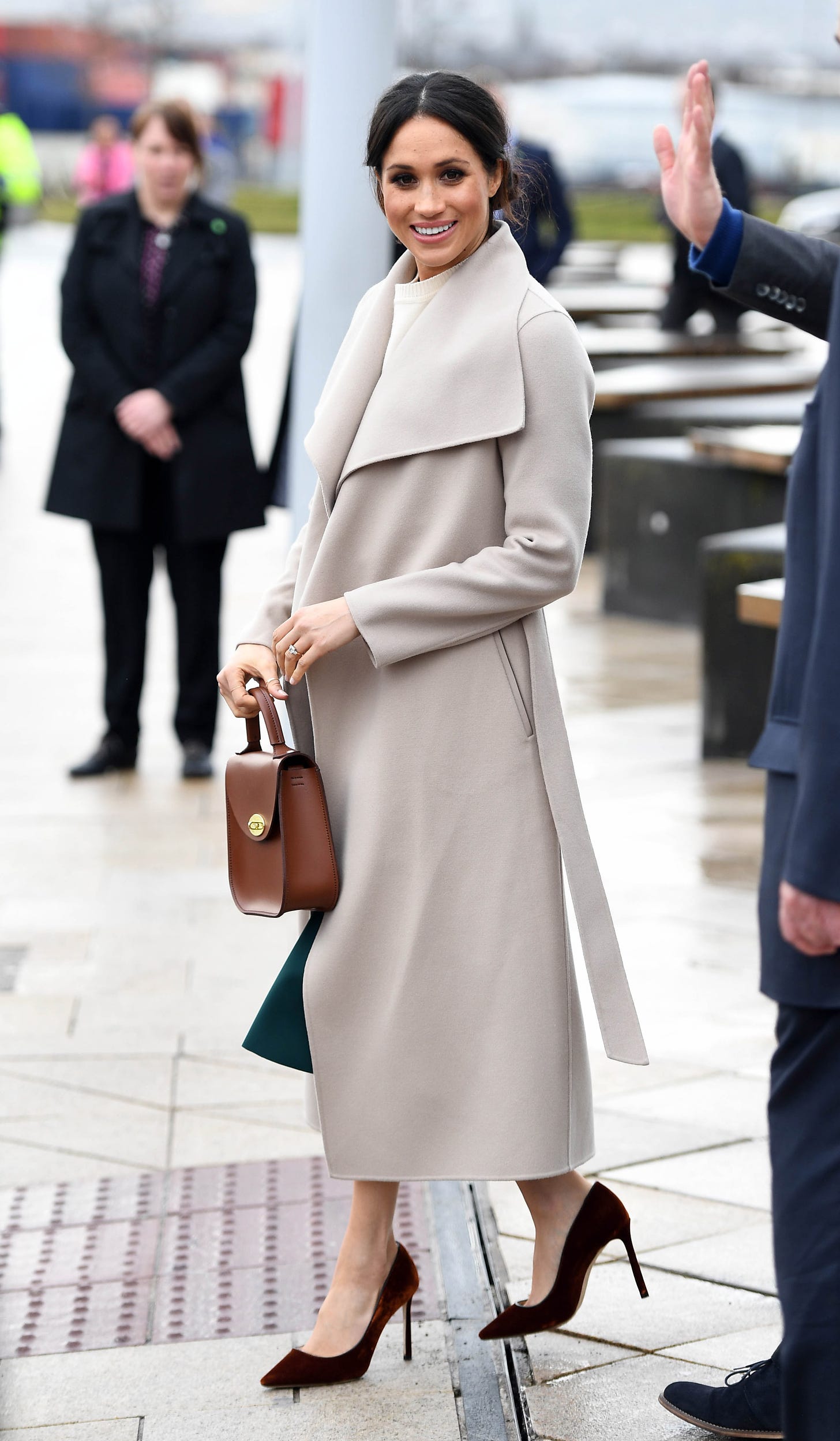 Meghan Markle wearing cream and green outfit in Northern Ireland with Charlotte Elizabeth bag. 