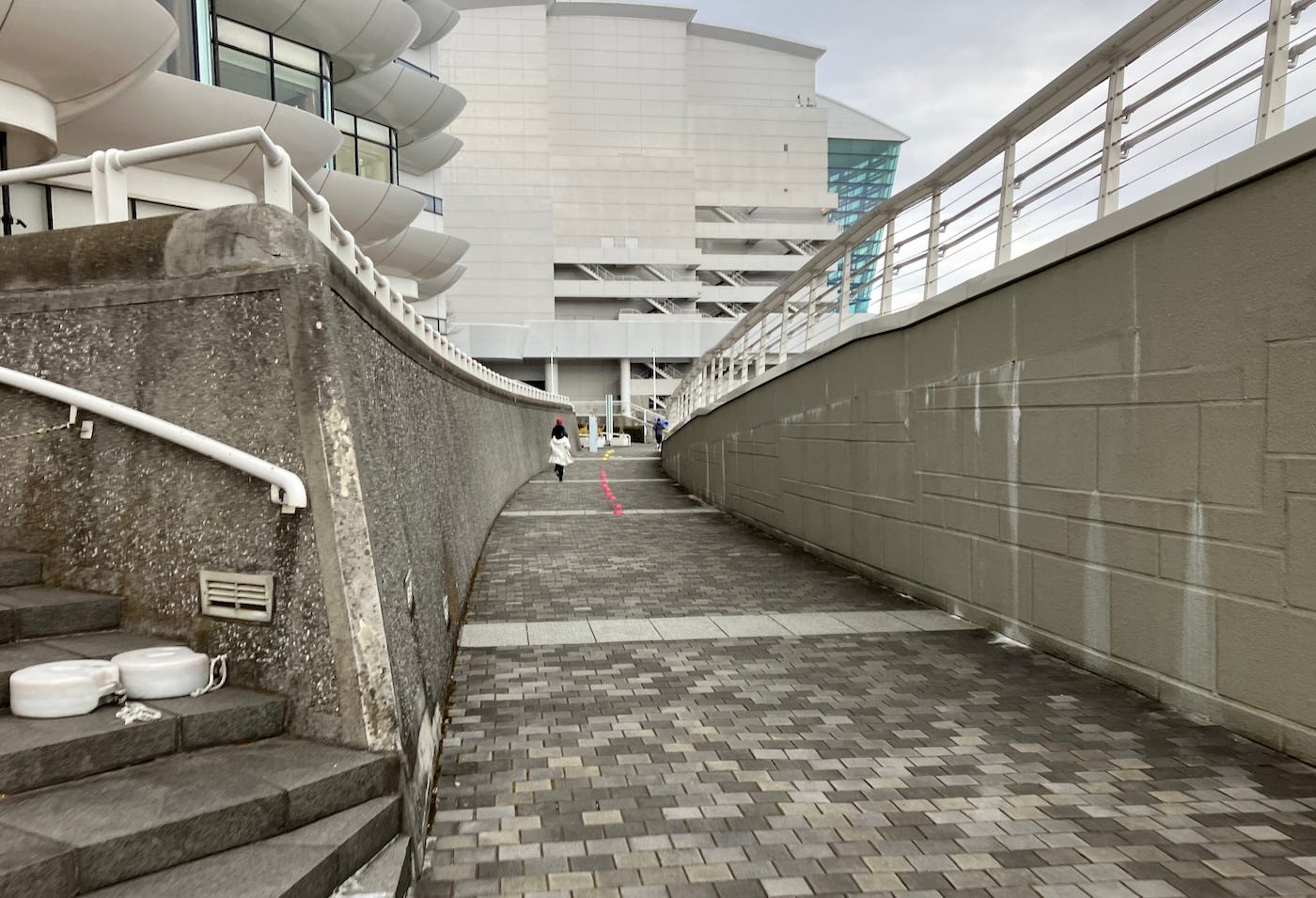 An alley with a slight rise, between a bridge and hotel