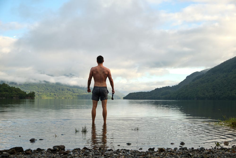 May be an image of 1 person, mountain and lake