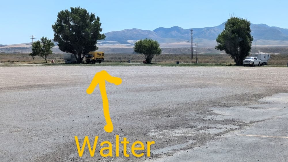 a large barren parking lot with Walter the big yellow truck at one far end, so small and distant