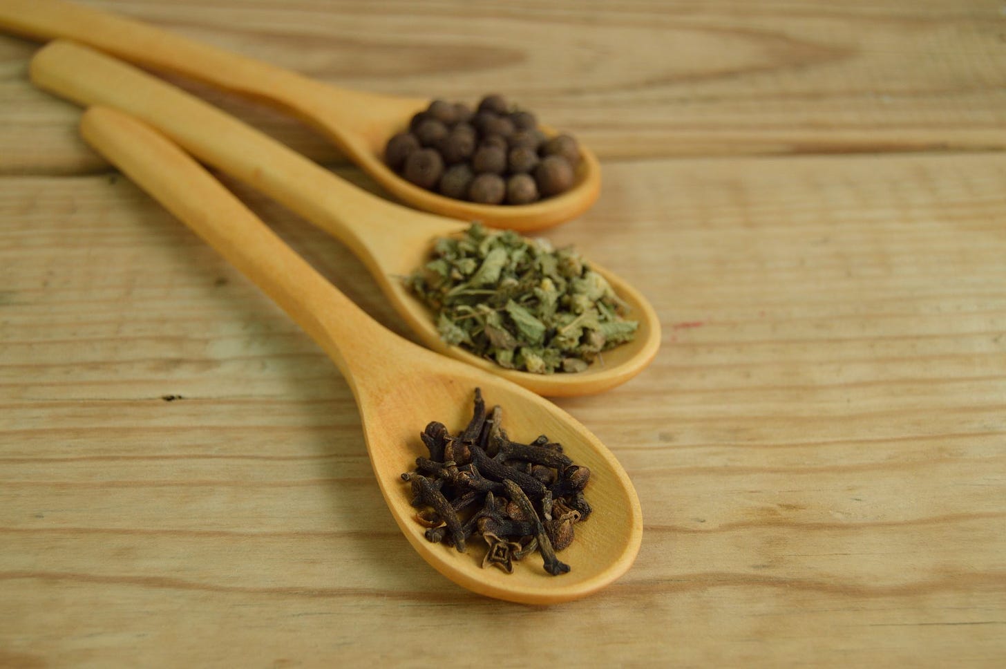 Photo of spices on brown measuring spoons by Miguel Á. Padriñán