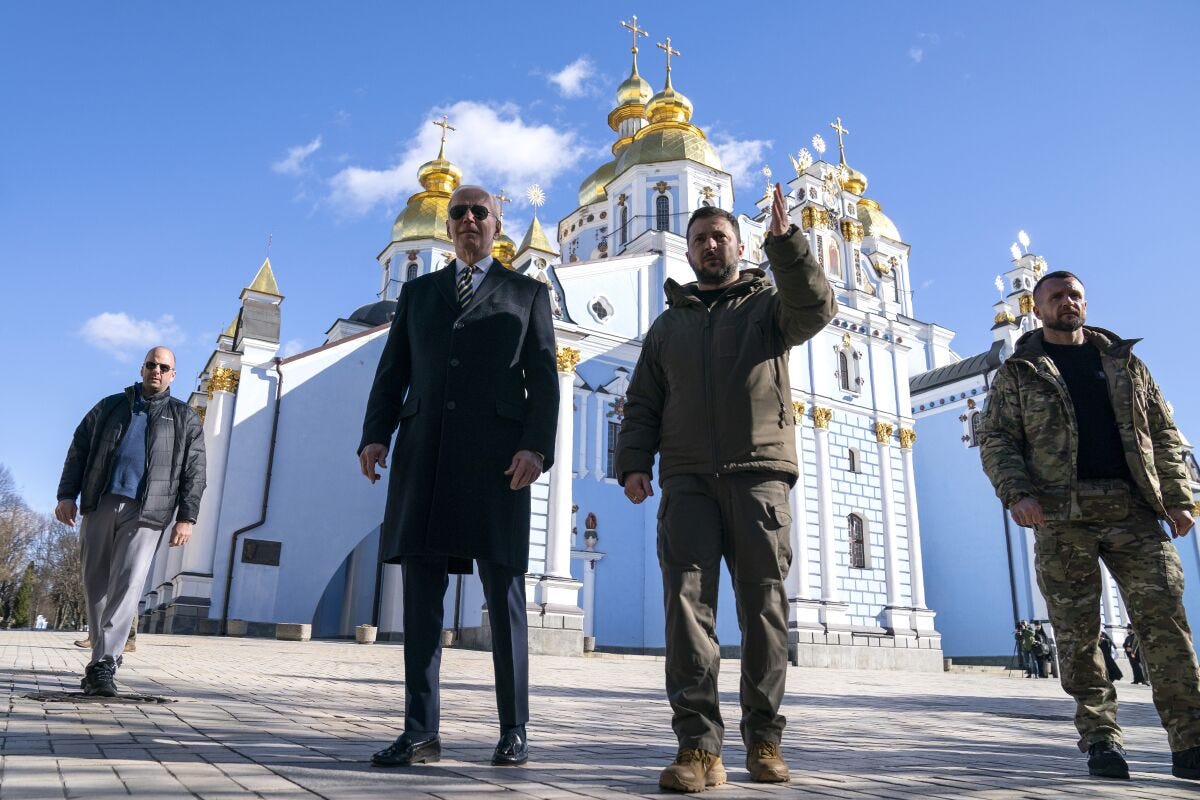 President Joe Biden walks with Ukrainian President Volodymyr Zelenskyy in front of a golden-domed cathedral