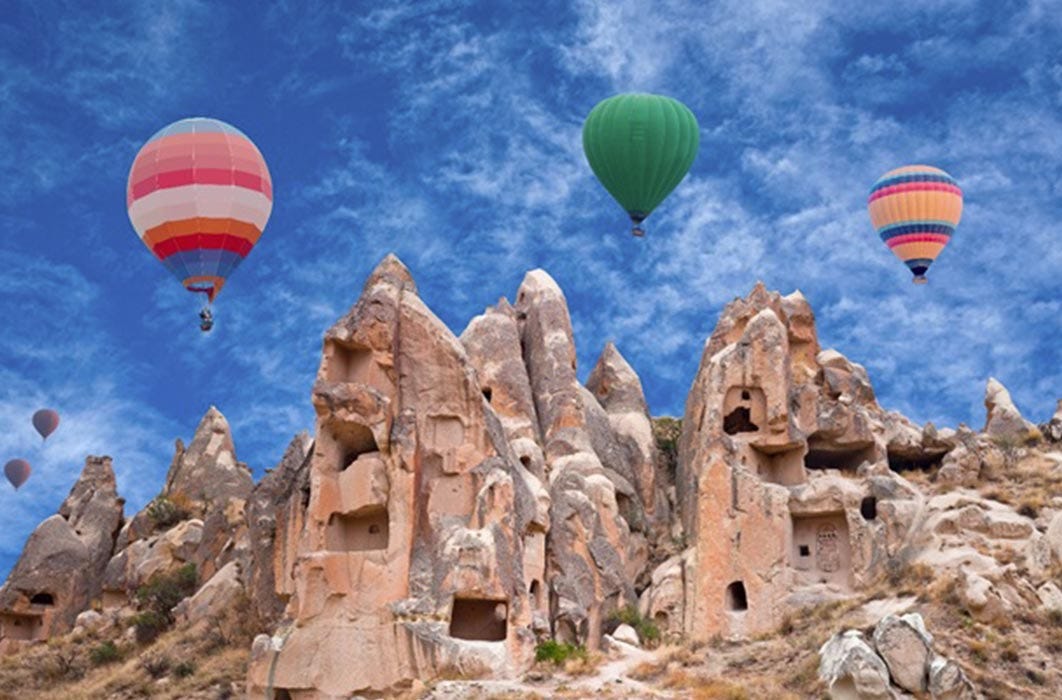 Colorful hot air balloons flying over Red valley in Cappadocia, Anatolia, Turkey (Svetlana Nikolaeva/ Adobe Stock)