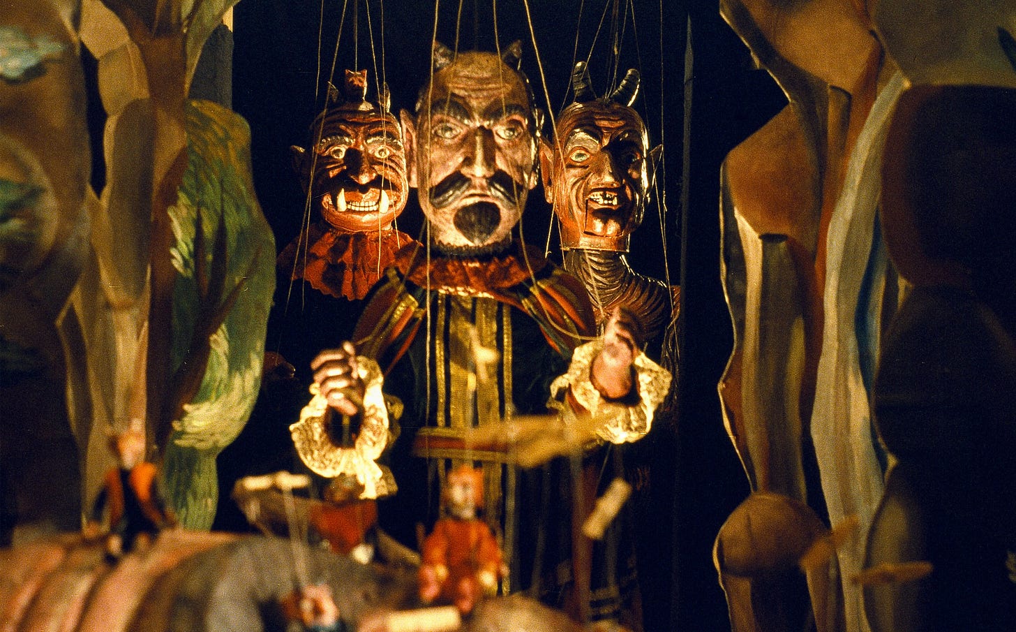 A marionette of the devil in traditional Czech style, flanked by two marionettes of demons.