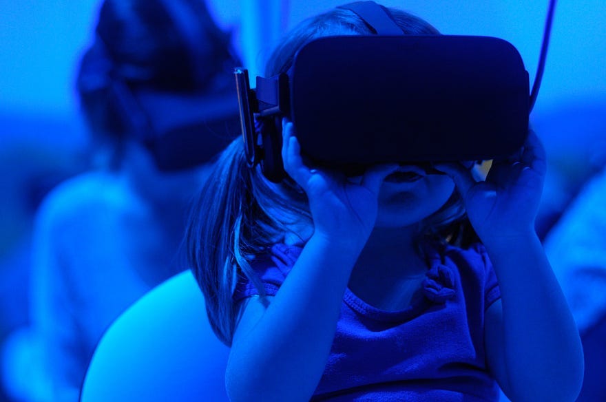 Child wearing VR helmet in eerie blue lighting