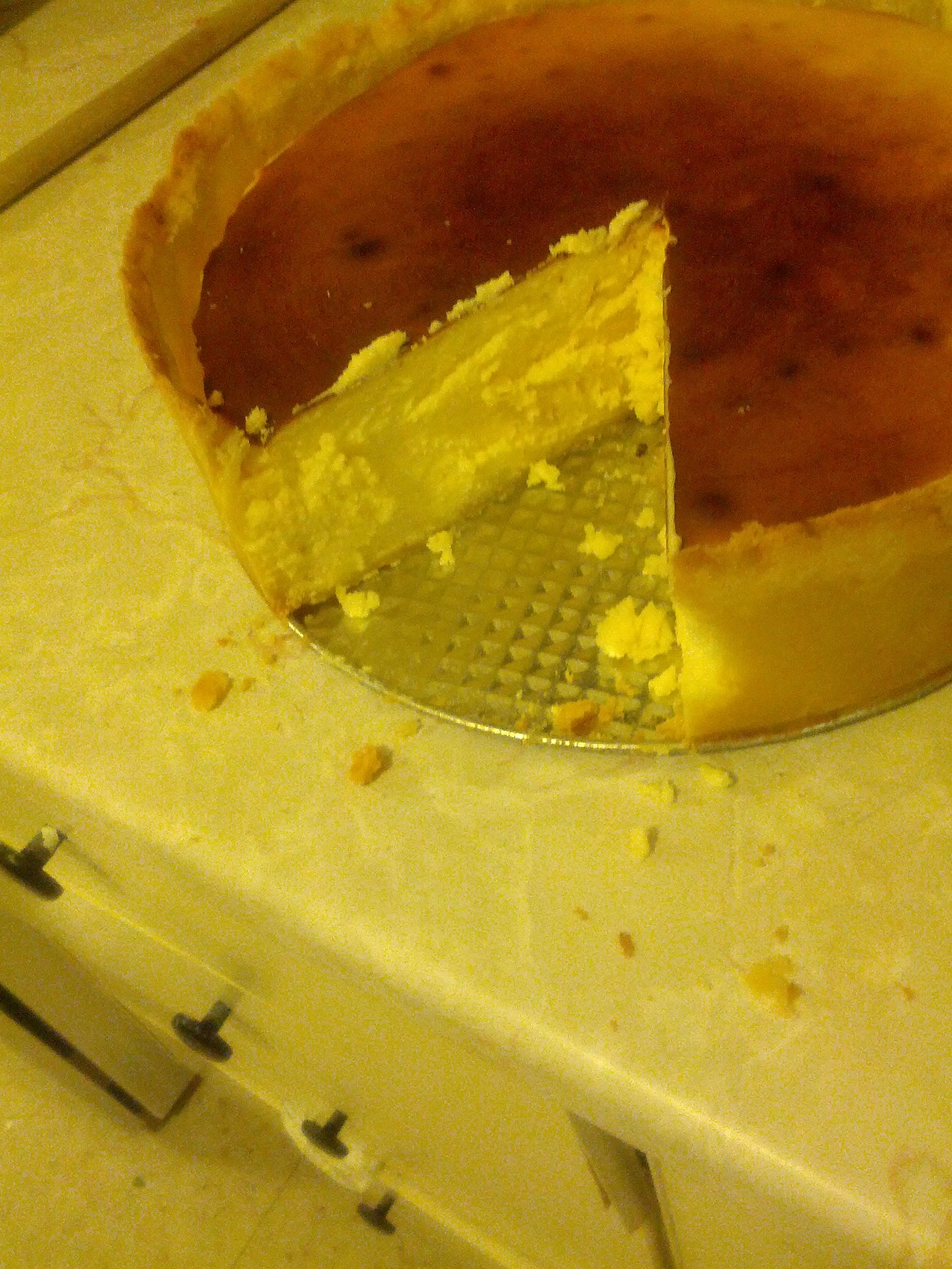 cheesecake with a slice taken out of it, on a counter