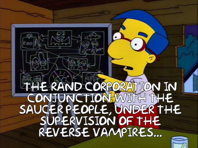 From The Simpsons: Milhouse explains a conspiracy theory on a chalkboard in Bart's treehouse. Caption reads: "The Rand Corporation in conjunction with the Saucer People, under the supervision of the Reverse Vampires..."