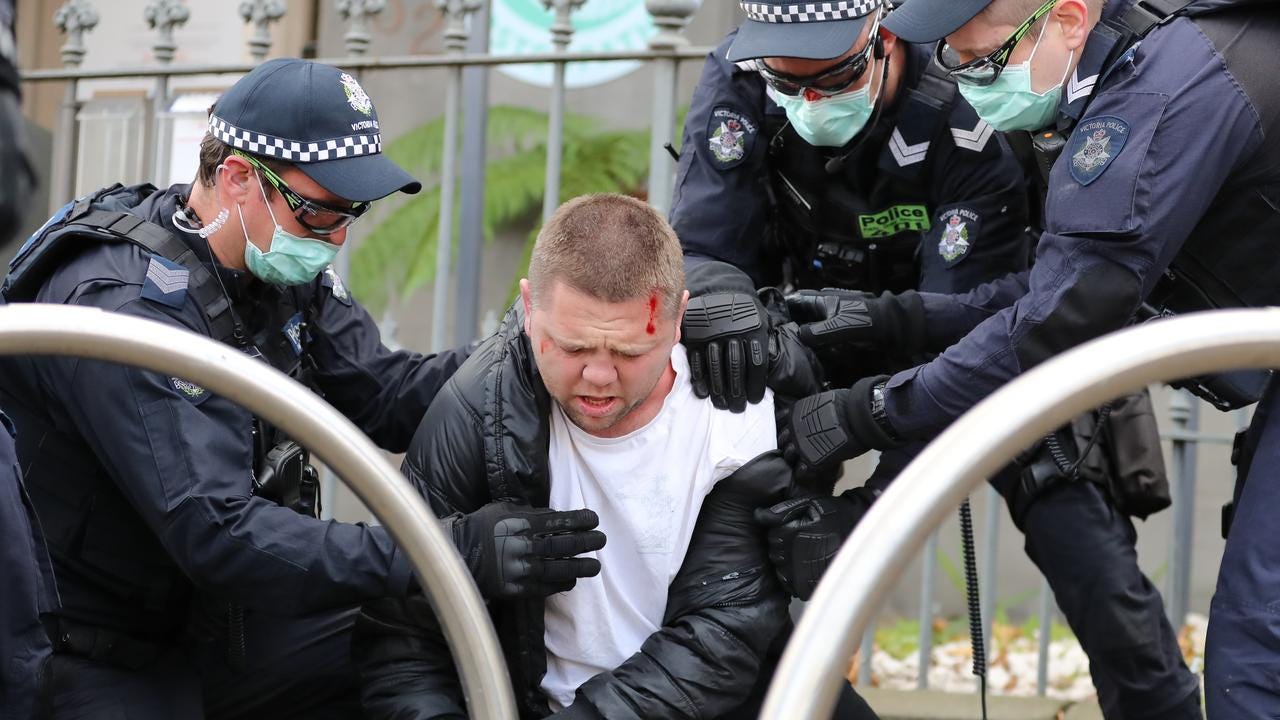 Officers tend to Nick Patterson after his arrest in North Melbourne following an anti-lockdown protest. Picture: Alex Coppel.