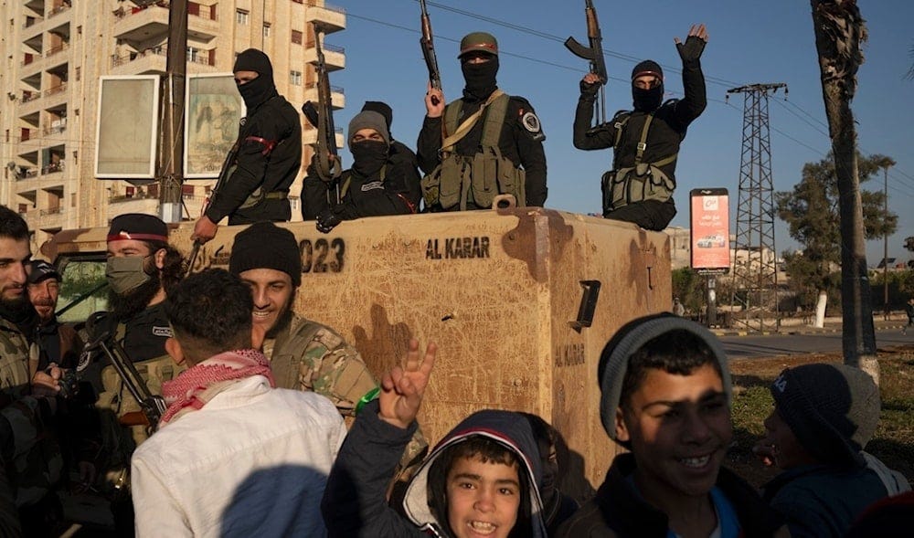 Members of the security forces of the newly formed Syrian government stand on an armored vehicle in Homs, Syria, Thursday, Jan. 2, 2025. (AP)