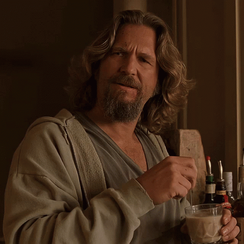 The Big Lebowski stirs a small glass full of a white russian with a glass stirring stick. He looks profoundly confused.