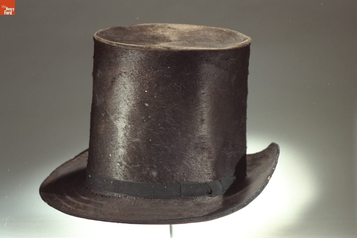 Somewhat battered black top hat