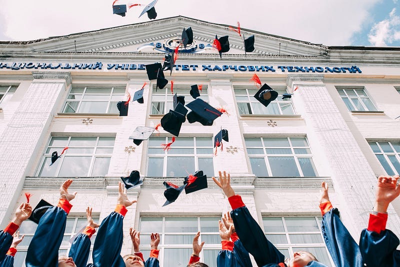 Graduating students throwing their mortar boards in the air as celebrations