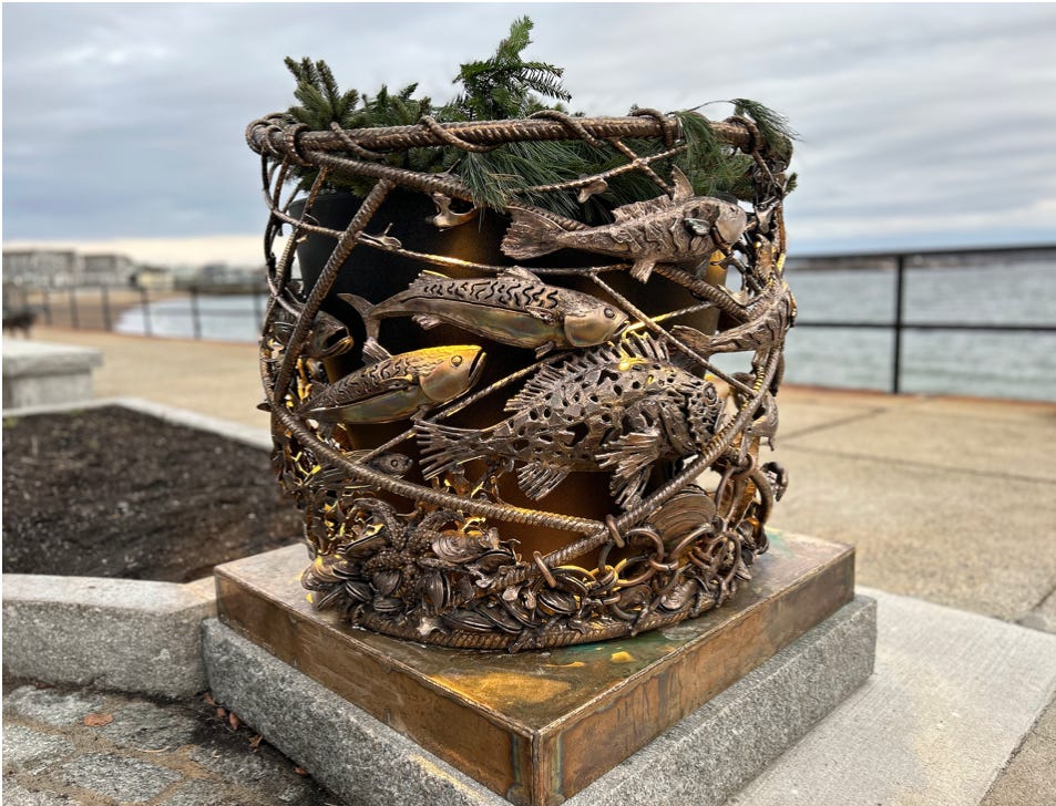 A metal basket with fish and plants on a concrete platform

Description automatically generated