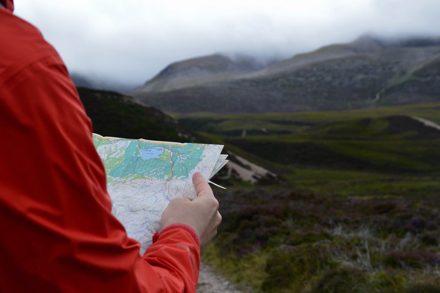 A person viewing an OS map of the Cairngorm mountain range in Scotland