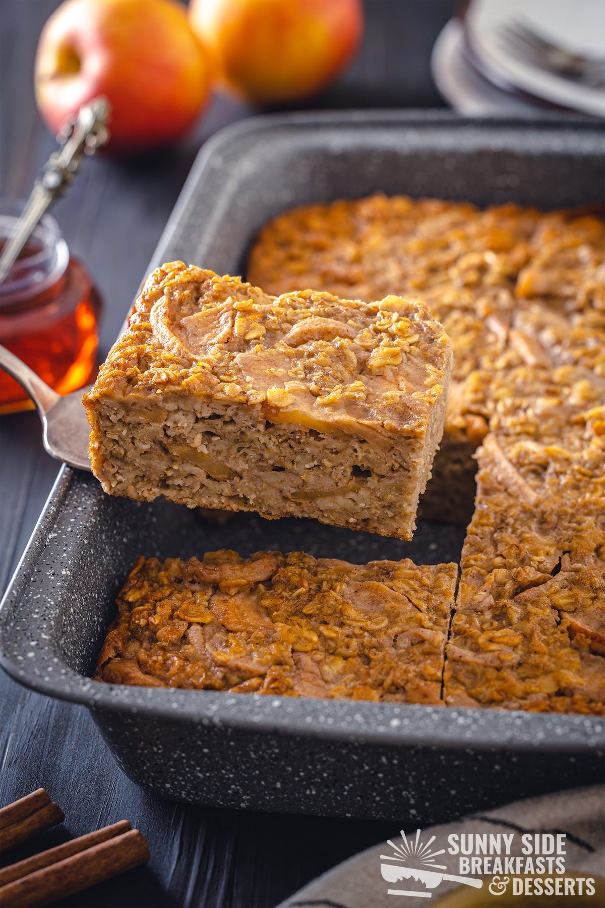 A spatula lifting a slice of baked oatmeal out of the pan.