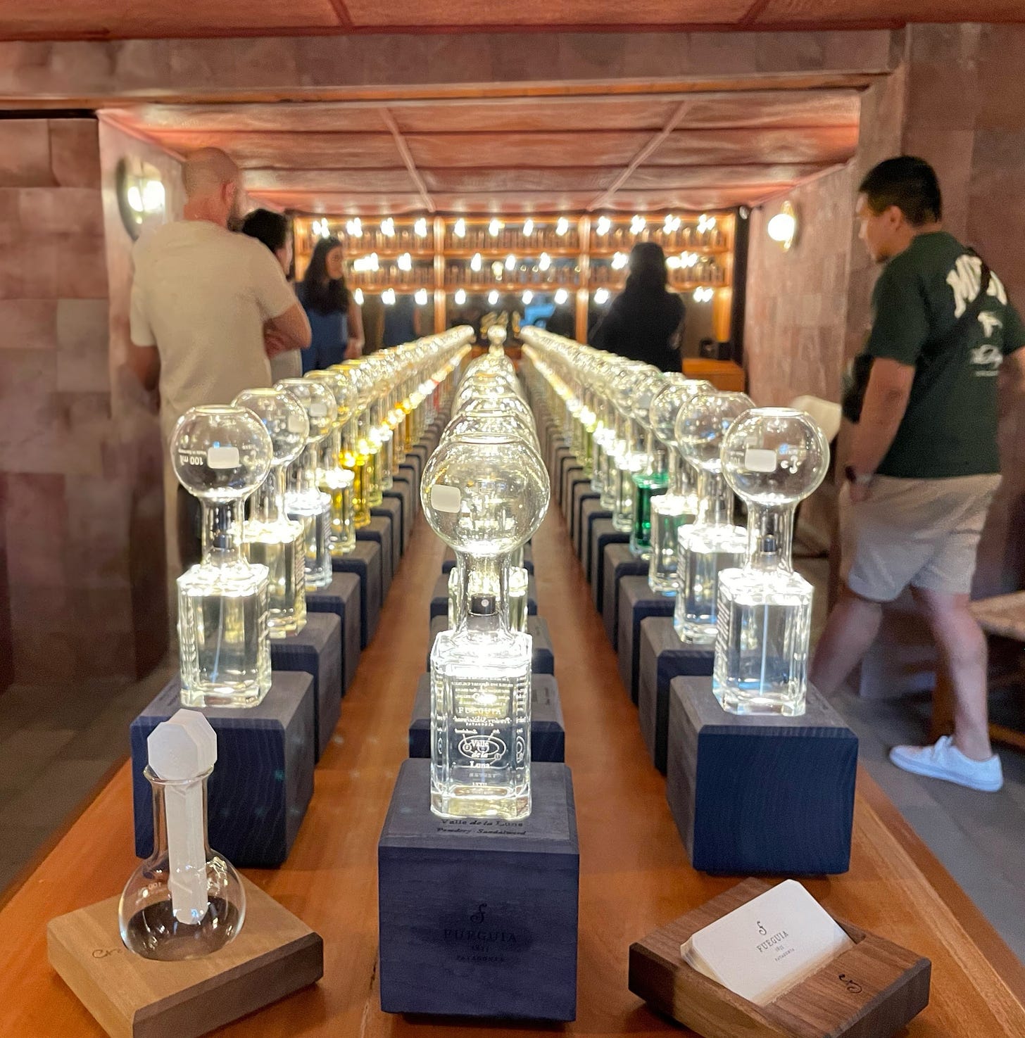 A row of glass bottles hold cologne in an upscale, wood-paneled shop