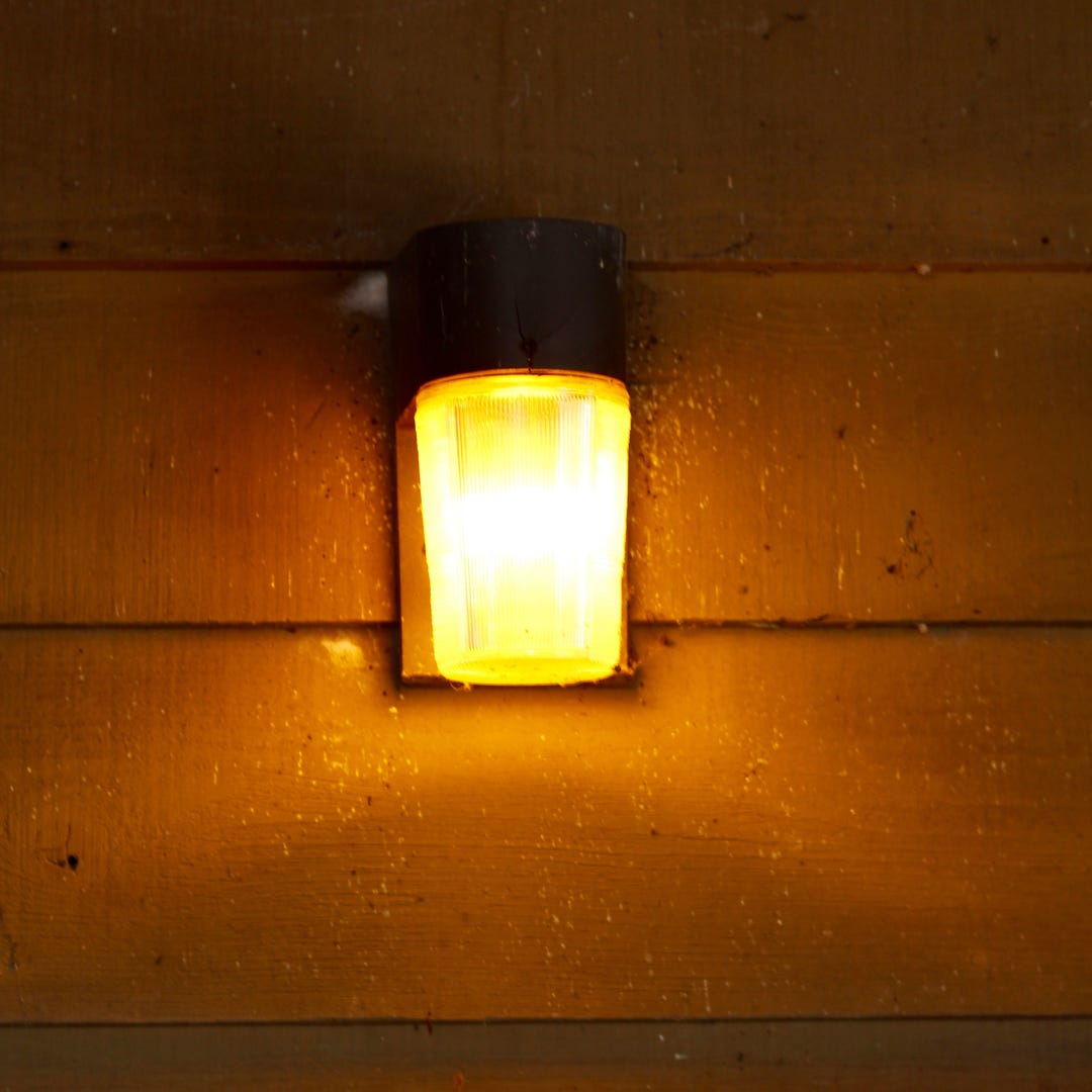 another porch light lit at night, this one simpler