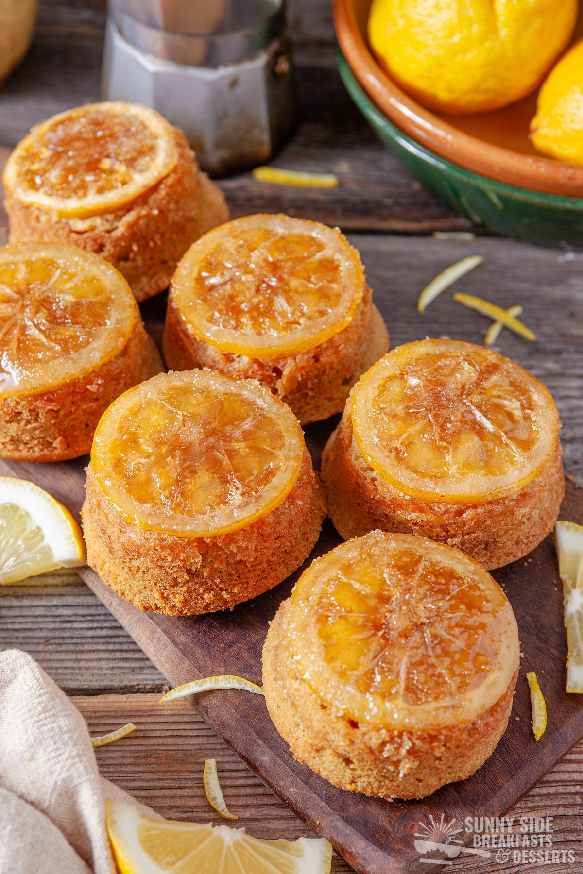 Lemon cakes on a wood cutting board.