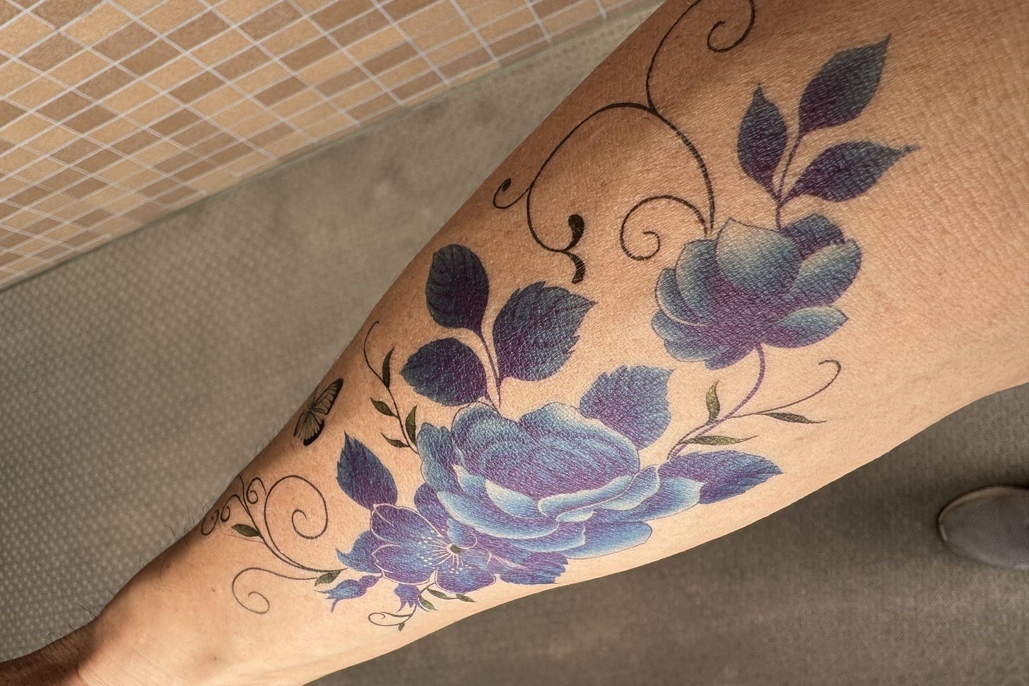 Tattoo of blue flowers in arm