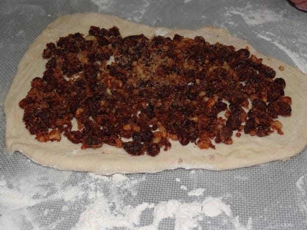 A dough with brown toppings on it

Description automatically generated