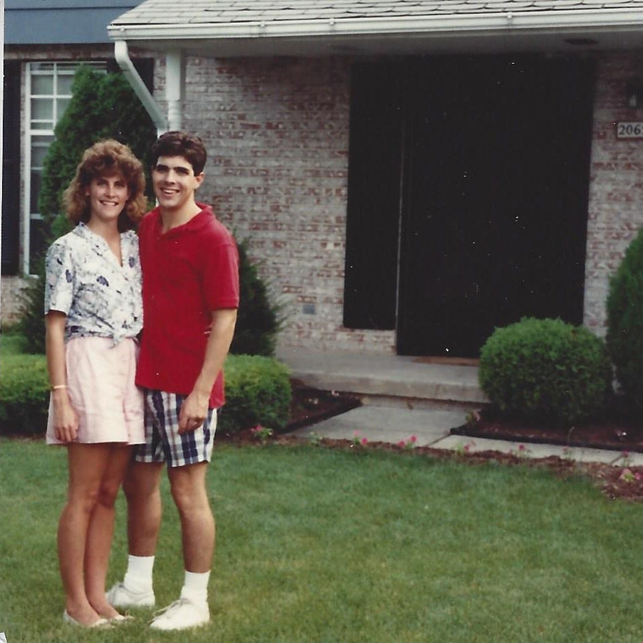 Young couple posed proudly in front of their first house