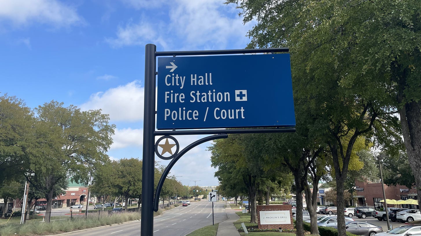 A blue sign indicating the location of Coppell's city hall, police headquarters, and a fire station