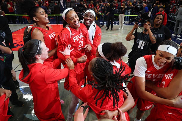 Caitlin Clark of the Indiana Fever and DeWanna Bonner celebrate a win with teammates against the Chicago Skyin the Fever's home opener at Gainbridge...