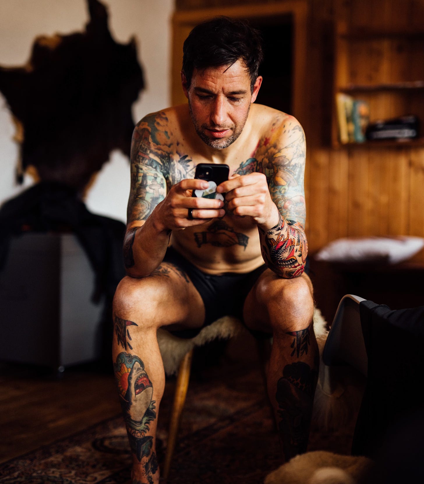 The author sitting on a chair, checking his smartphone