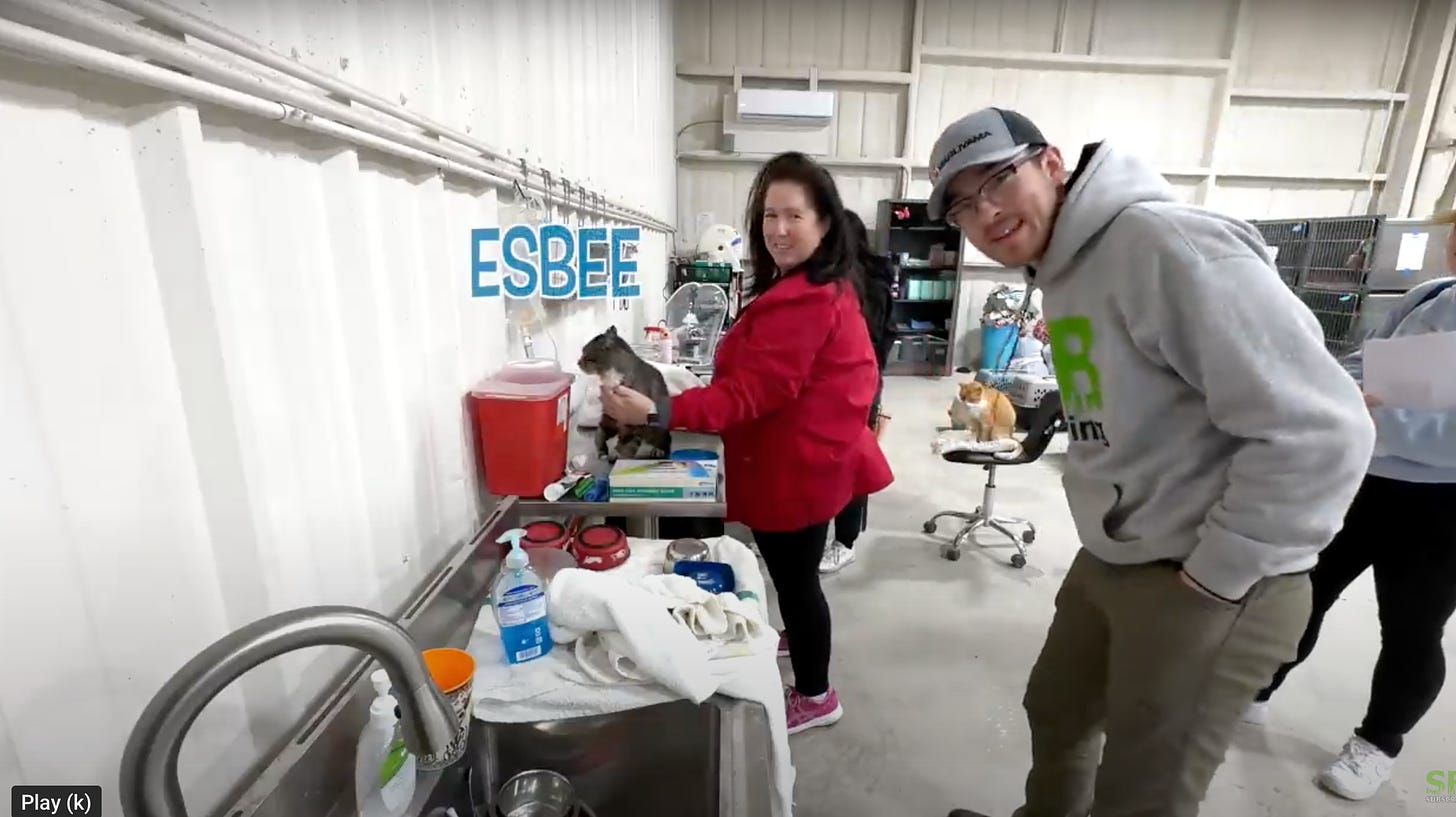 A frame grab from SB Mowing video showing cat (Esbee), cat sanctuary Director Anissa Beal, and Spencer B.