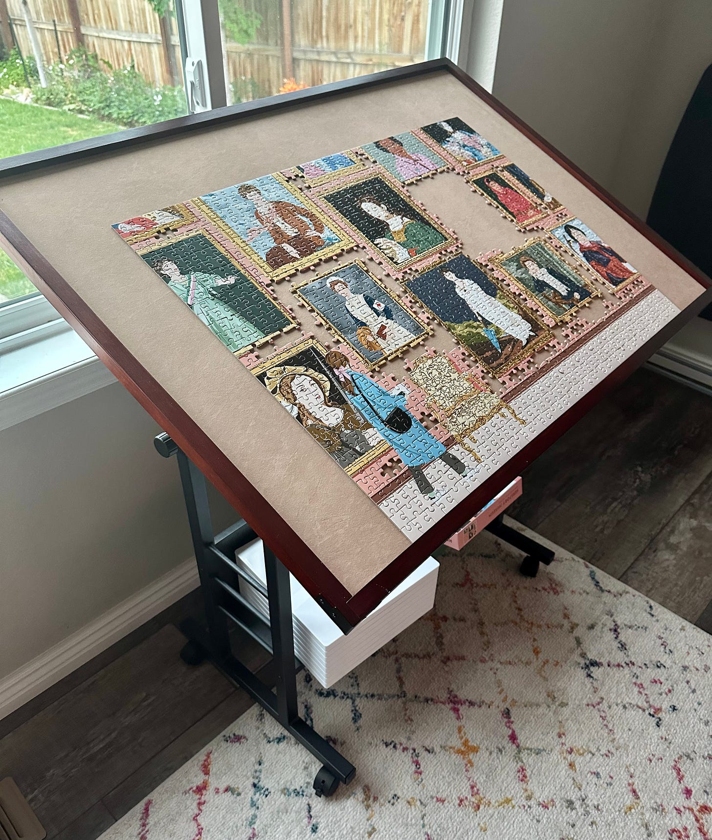 A large puzzle table with an almost-finished puzzle on it that shows famous women in history in frames in a gallery.