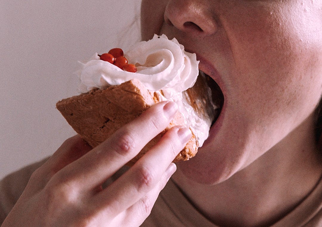 Woman putting pie in her mouth