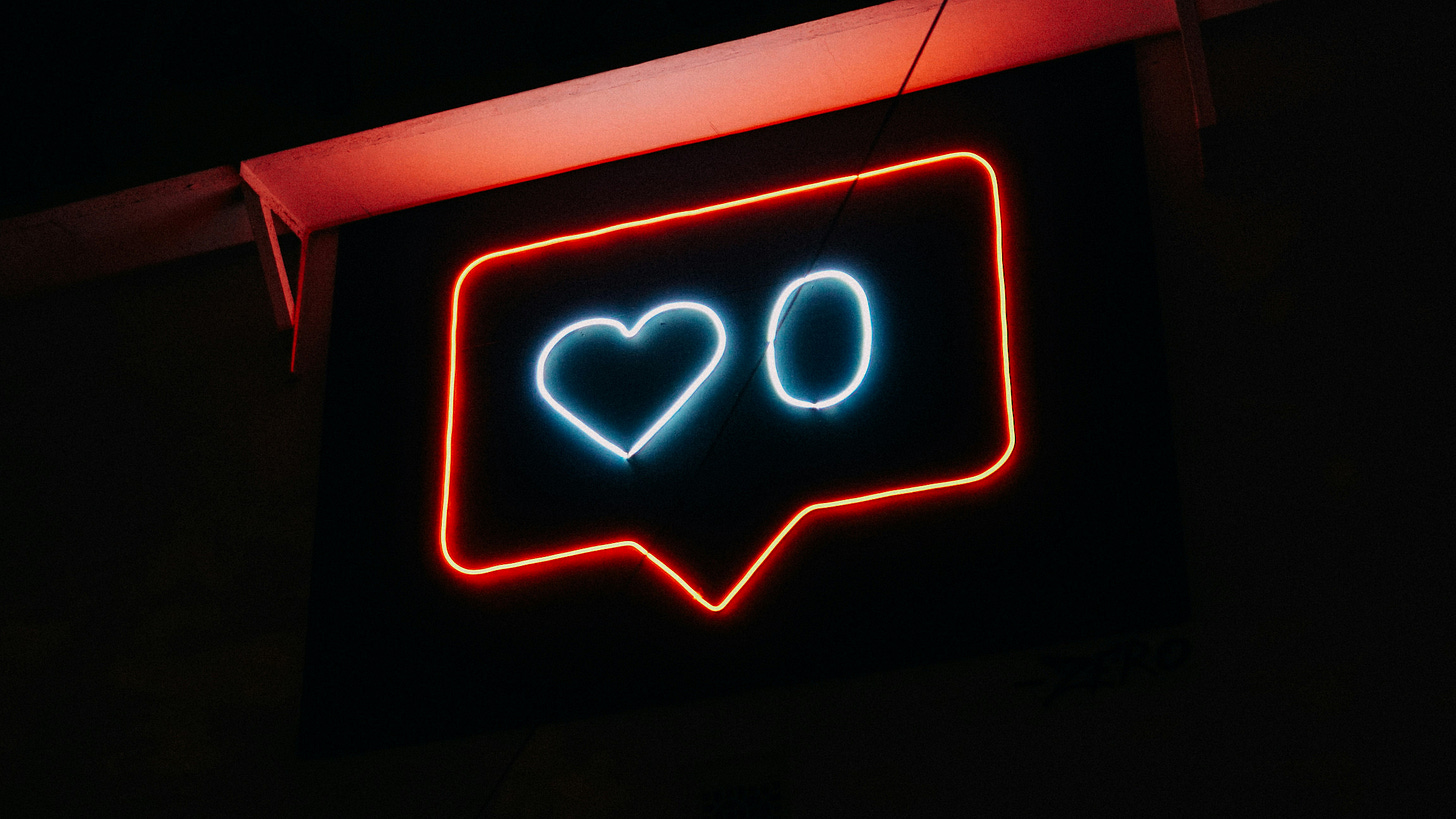 Neon sign of like emoji with a zero next to it Neon sign of like emoji with a zero next to it