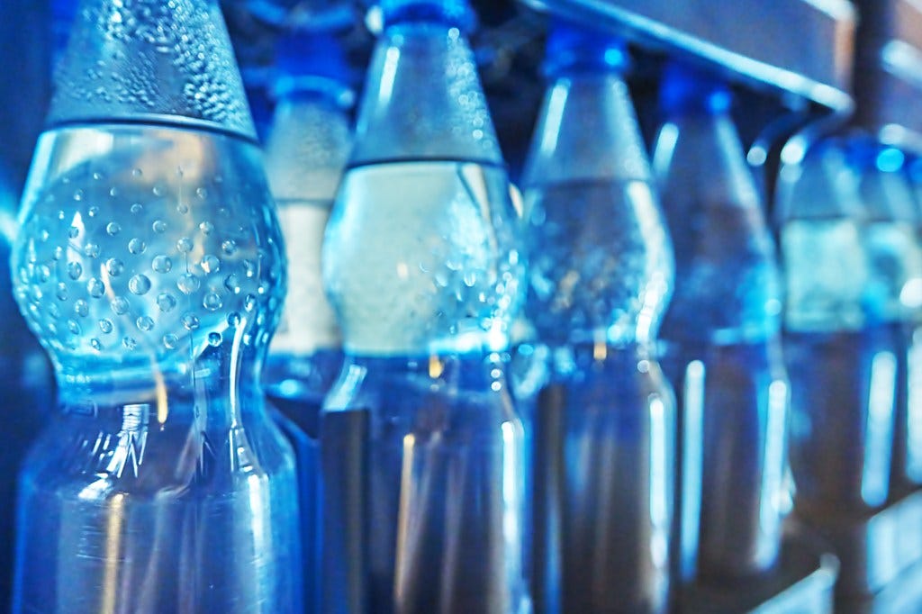 Bottled water was America’s favorite packaged drink last year, but it's also a significant source of microplastics. A row of bottled waters is shown here.