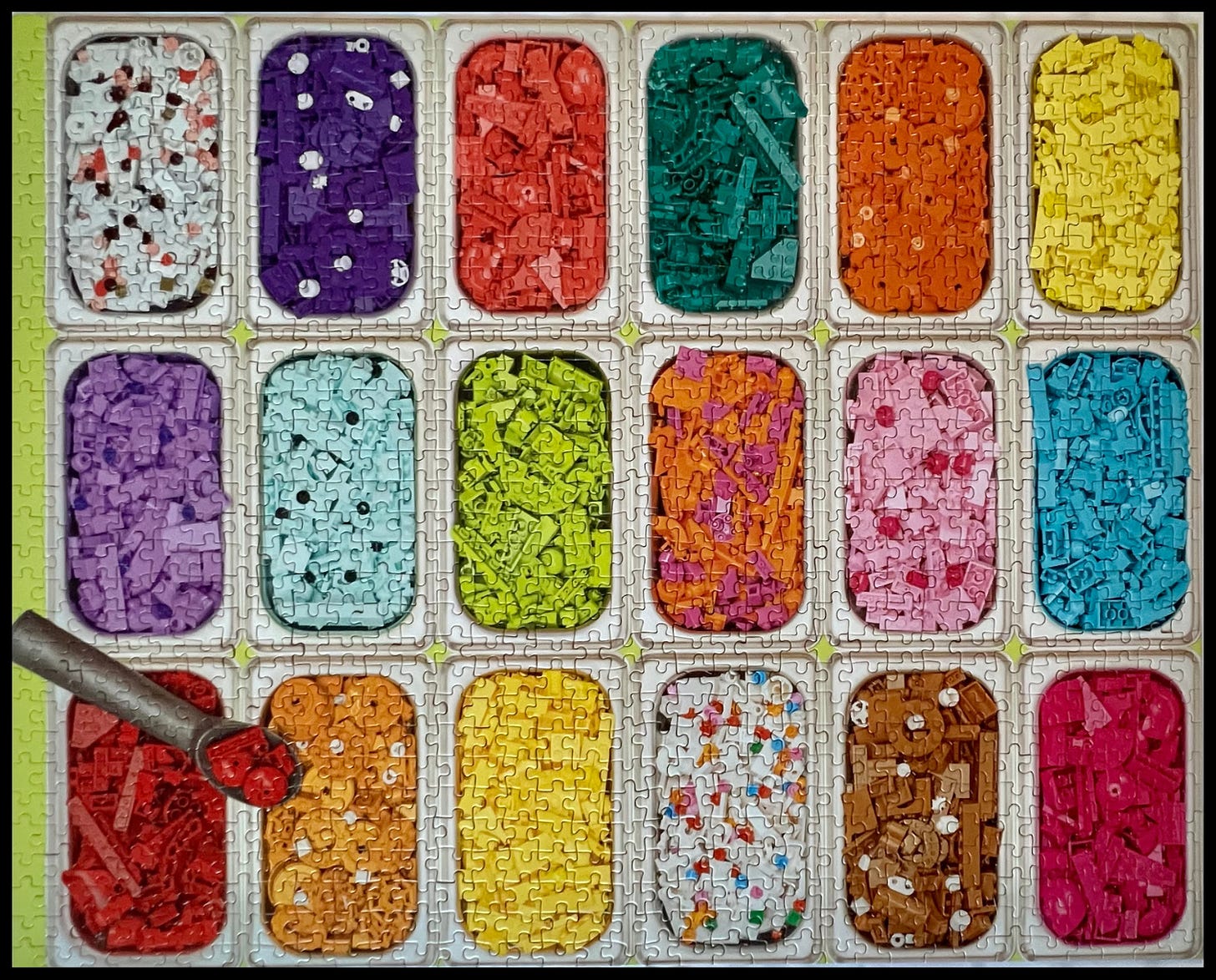 Picture of a completed puzzle. Colorful lego pieces sorted by color in compartments to look like ice cream, an  ice cream scoop sits in the lower left-hand corner