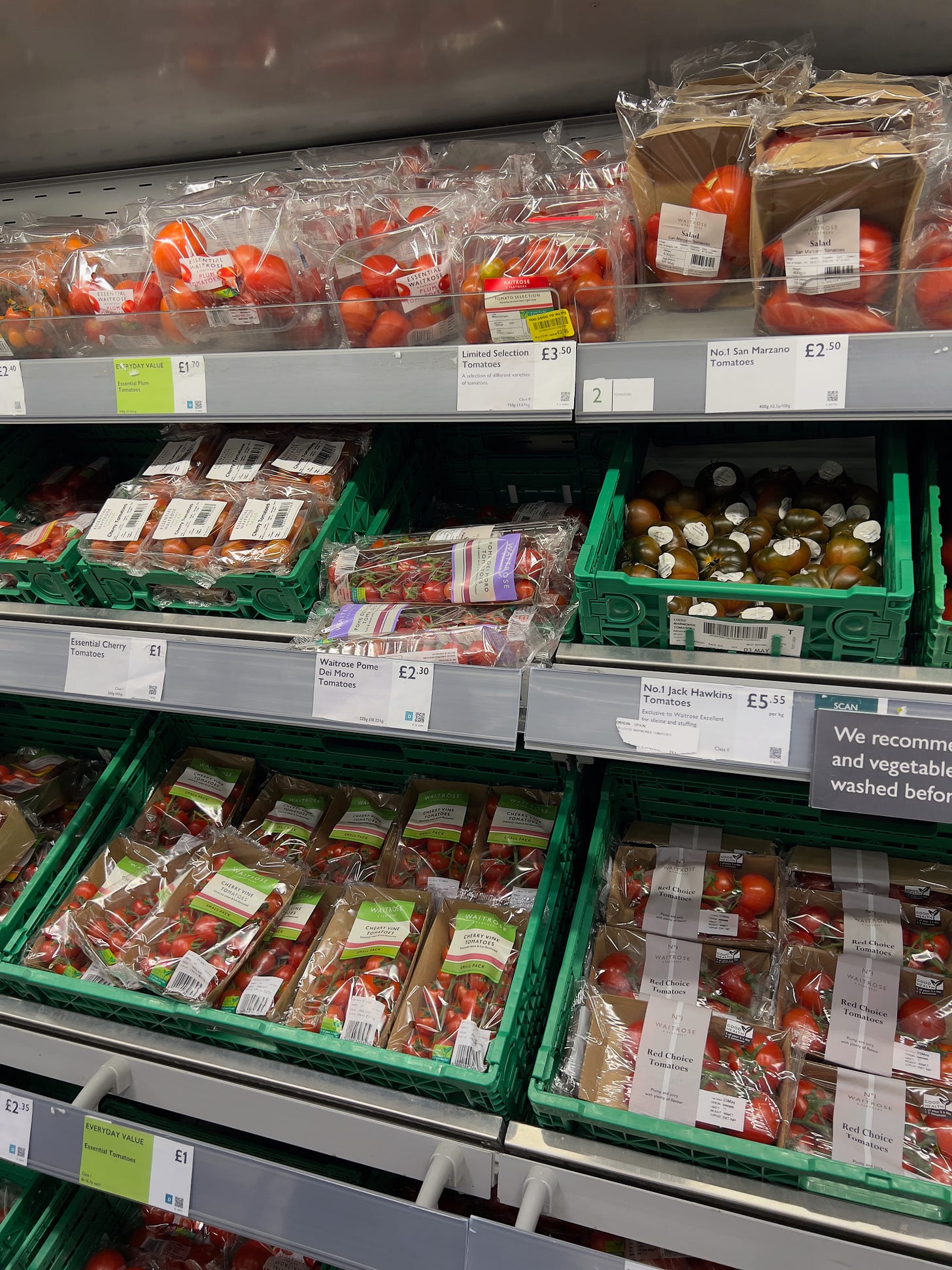 Picture of a variety of tomatoes packaged in single use plastic in Waitrose Supermarket, UK
