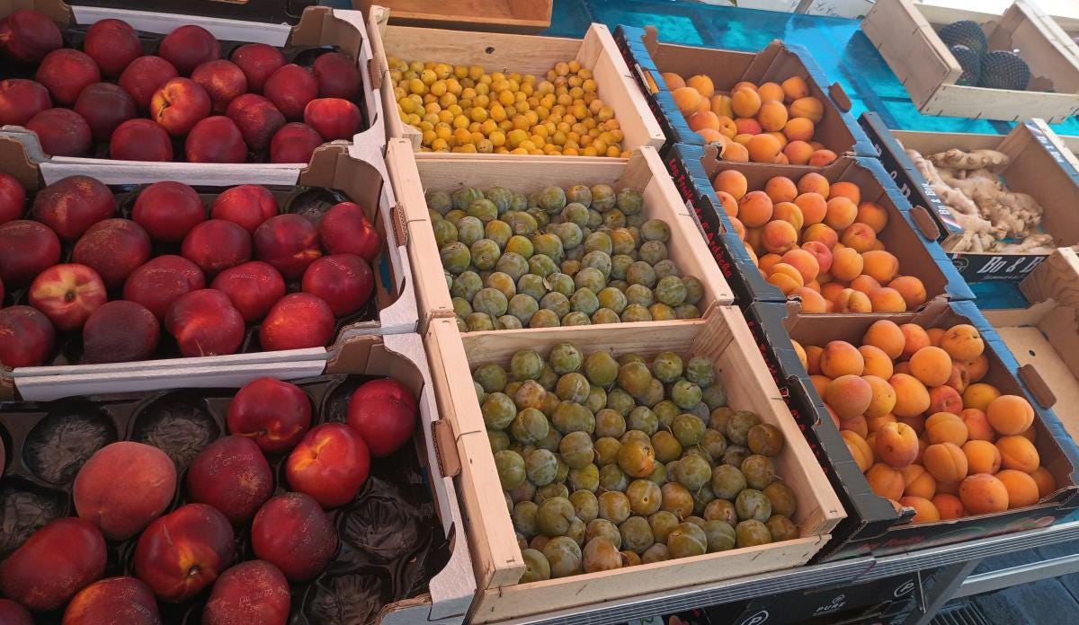  Peaches, ginger, and other fruit in crates on table