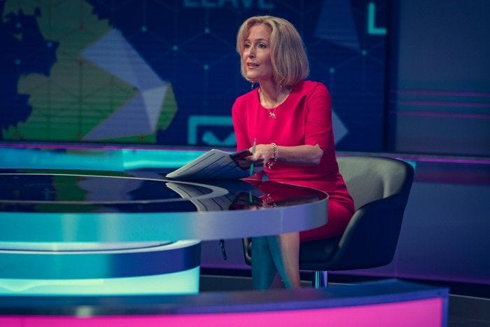 Gillian Anderson sits in a red dress as Emily Maitlis behind the Newsnight desk for Netflix film Scoop.