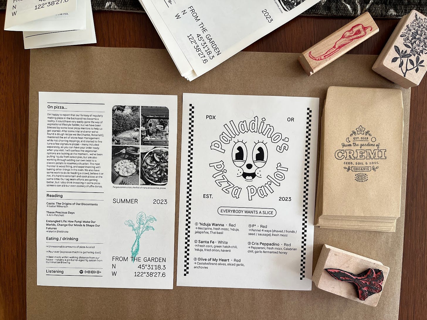 A spread of the zine, menu, stamps and seed packets