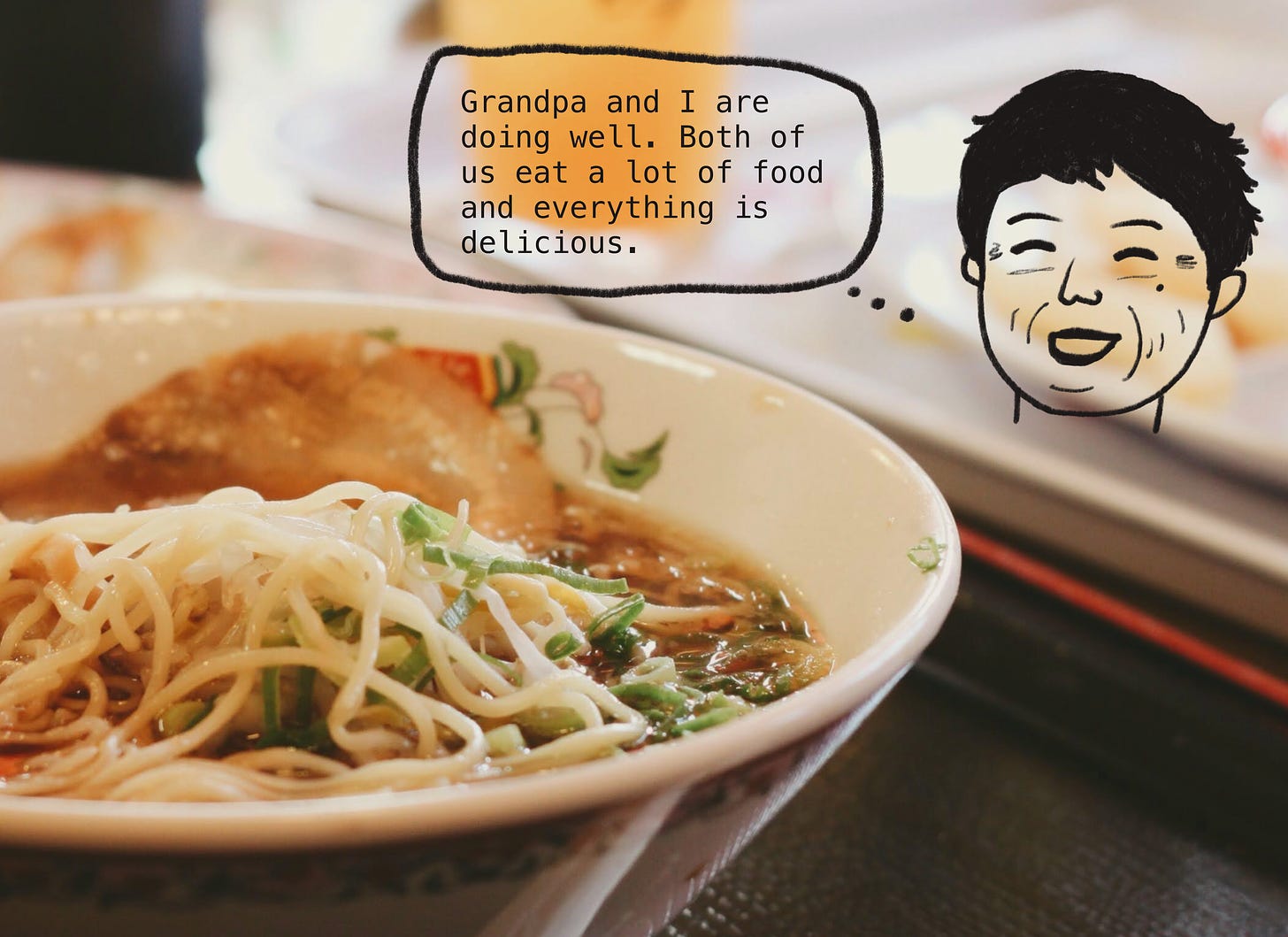 A bowl of ramen with an illustrated sketch of a Japanese grandma. A speech bubble says, "Grandpa and I are doing well. Both of us eat a lot of food and everything is delicious."