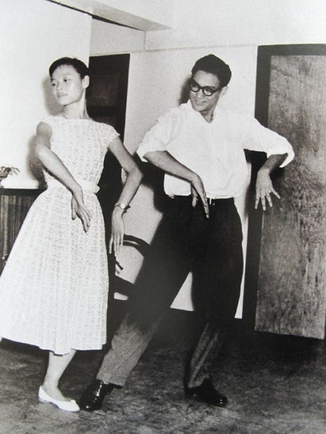 Bruce Lee dressed like a real take-home-to-mother-type is shown neatly executing the cha cha alongside a young woman in a dress with a gamine haircut.