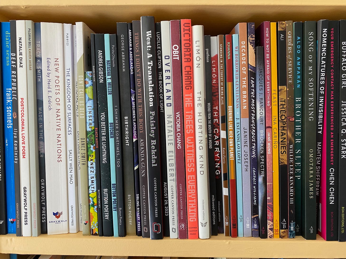 Closeup of a tightly-packed shelf of poetry collections.