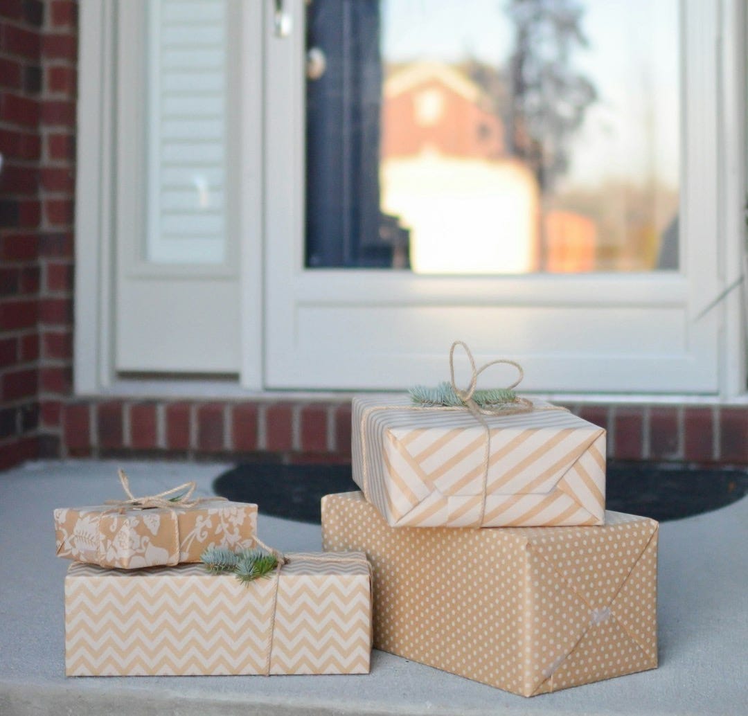 four brown gift boxes near white door