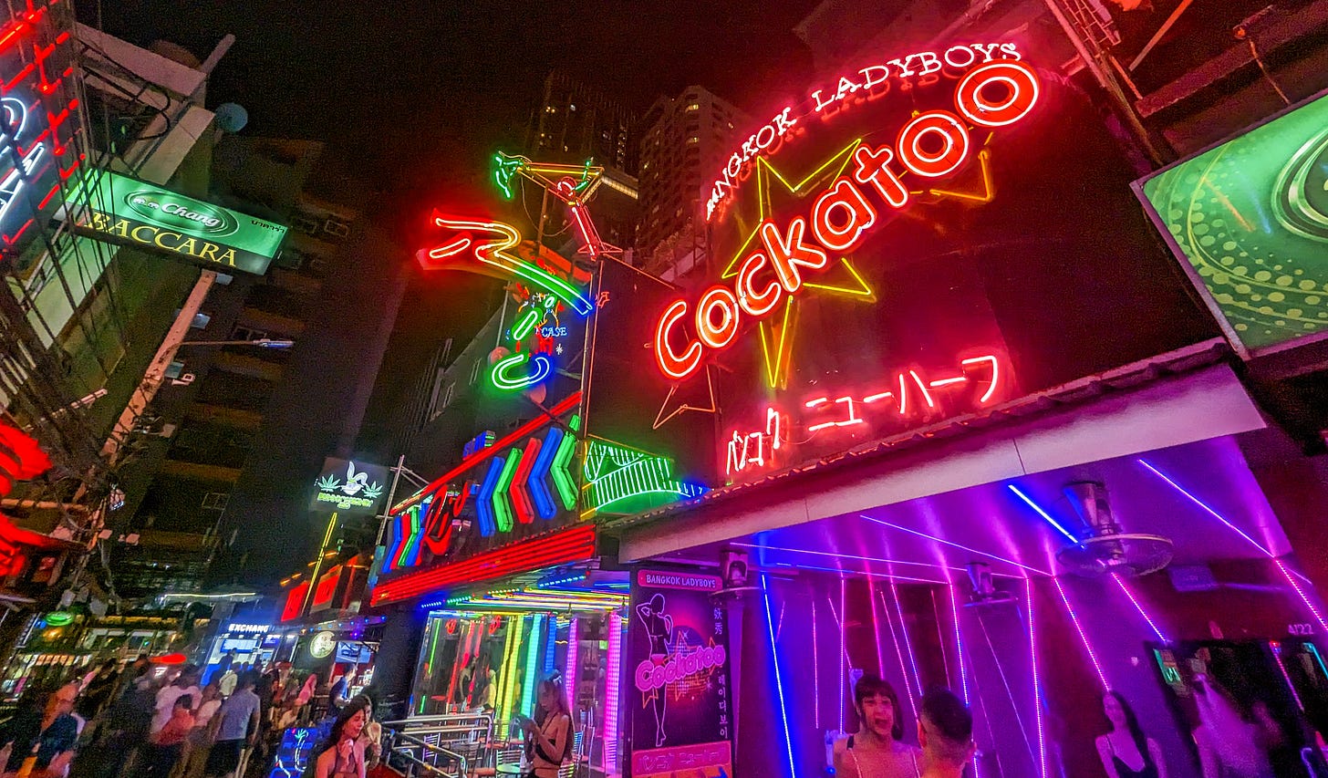 A vibrantly colored night picture of the neon signs along Soi Cowboy. 
