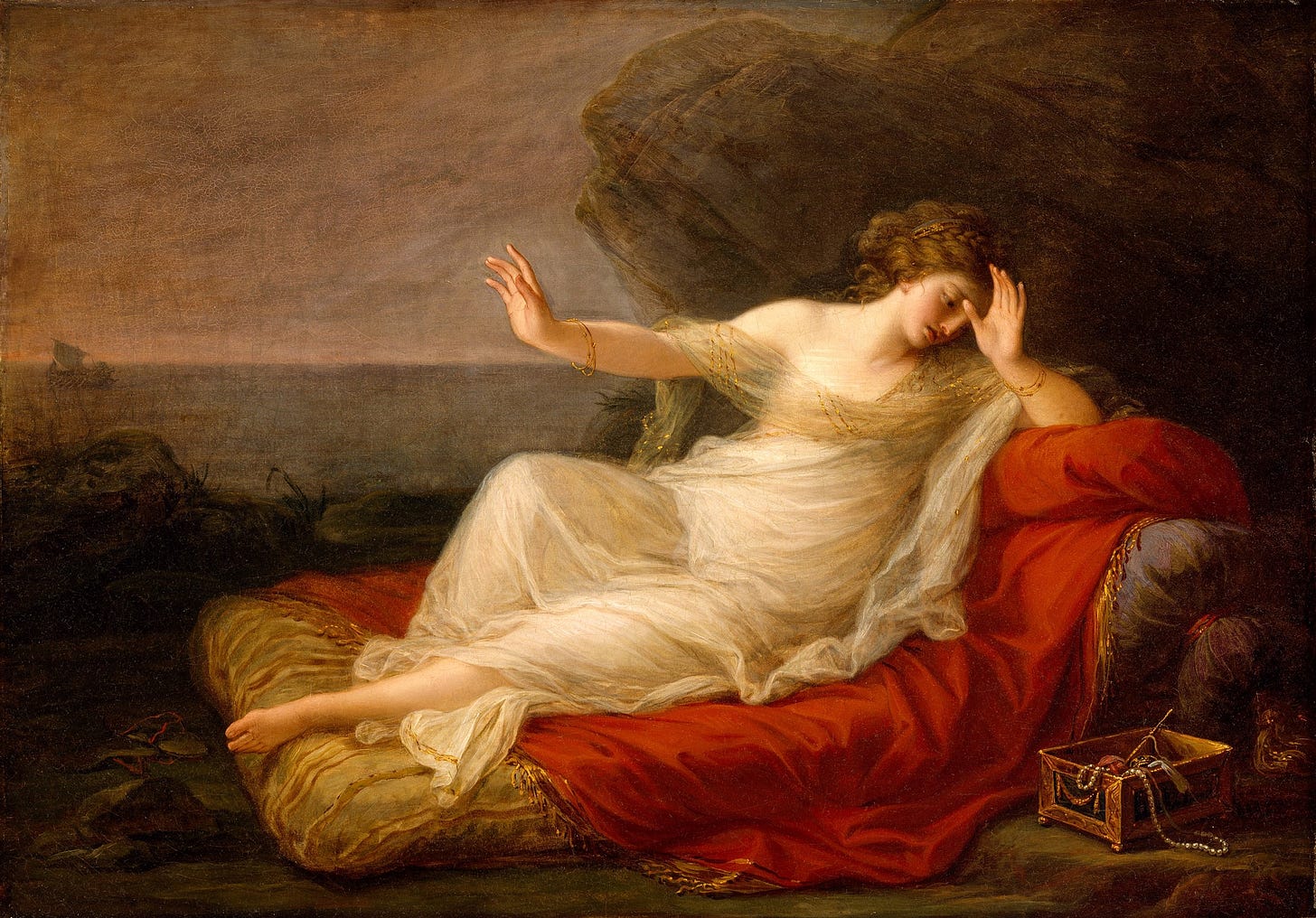 Woman in a white dress laying across a low cushion on a red blanket