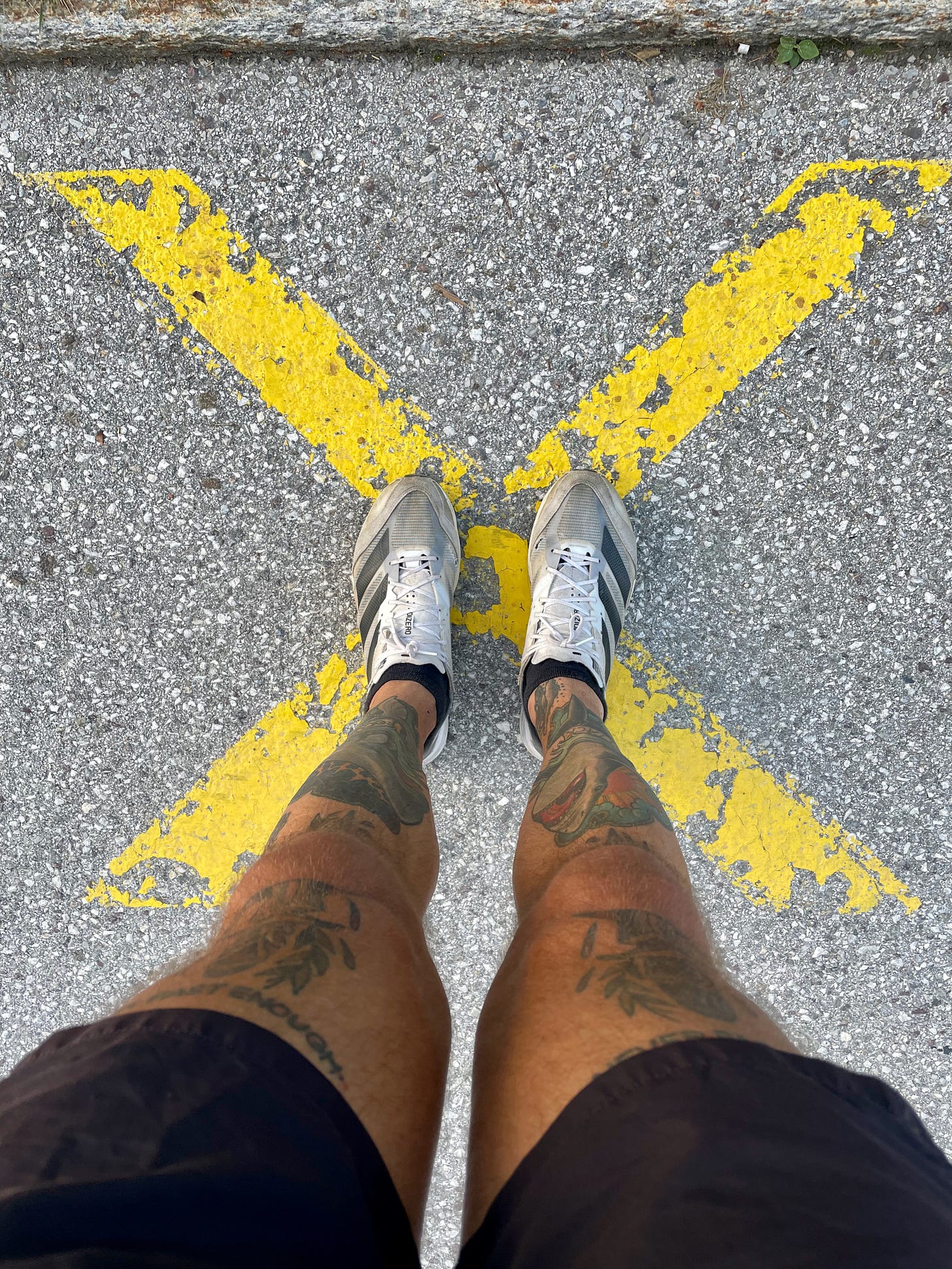 The author standing on an "X" painted on the ground wearing his favorite running shoes