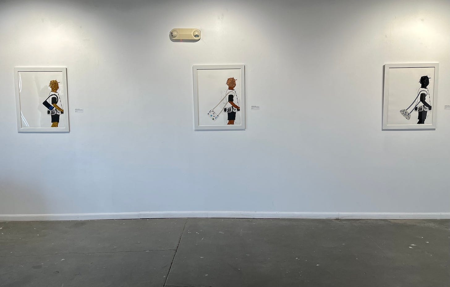 A photo of a wall at Harvester Arts, on which are installed three works from "Go'n Grab Your Little Purse," an exhibition by Shaunte' Levine. Each work looks almost identical: the artist used glitter, textiles and other materials to make each print unique.