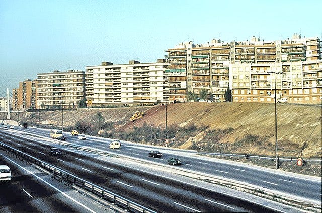 Photo of blocks of flats by a motorway.