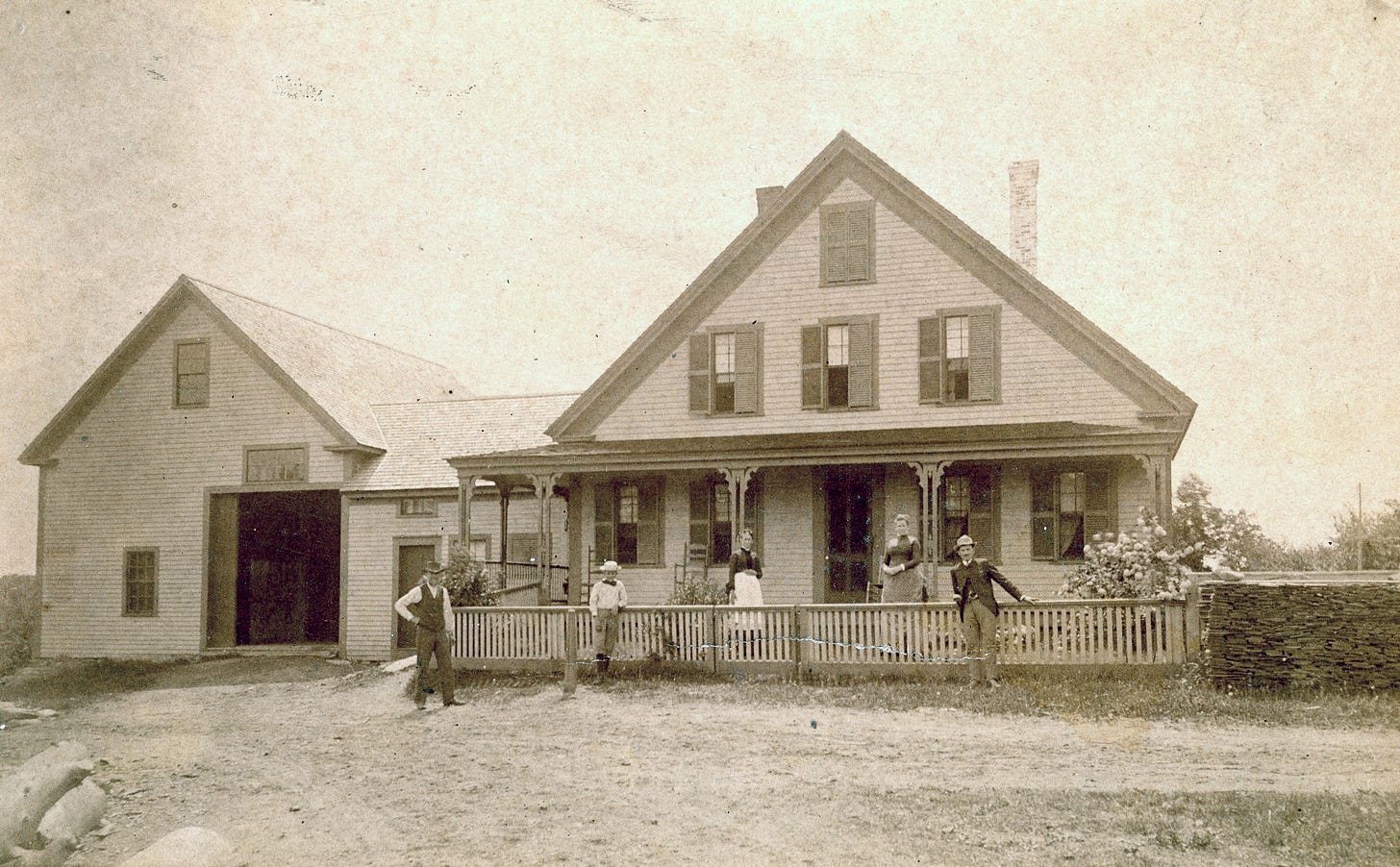 Four people in front of house and barn